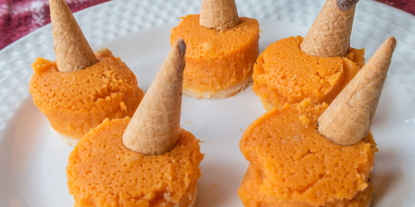 Photo of pumpkin pies topped with Muddy Bites, surrounded by festive themed decor.